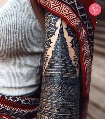 Pagoda tattoo on the upper arm of a woman