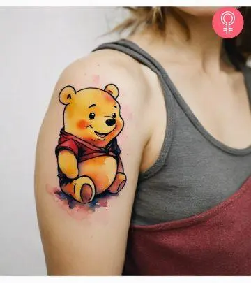 A woman with a vibrant frangipani flower tattoo on her upper arm