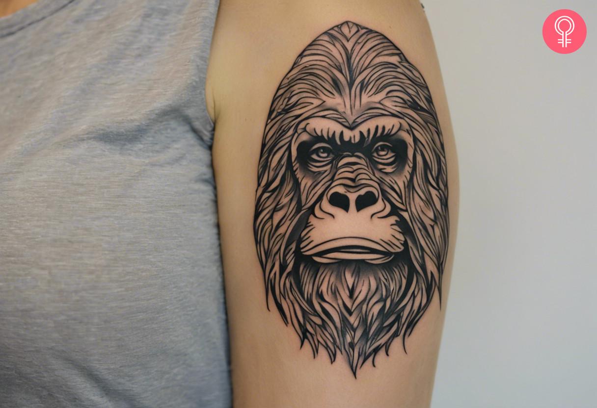 Bigfoot outline tattoo on a woman's upper arm