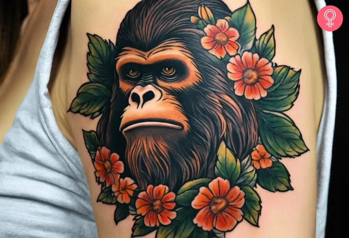 Bigfoot with flowers traditional tattoo on the upper arm of a woman