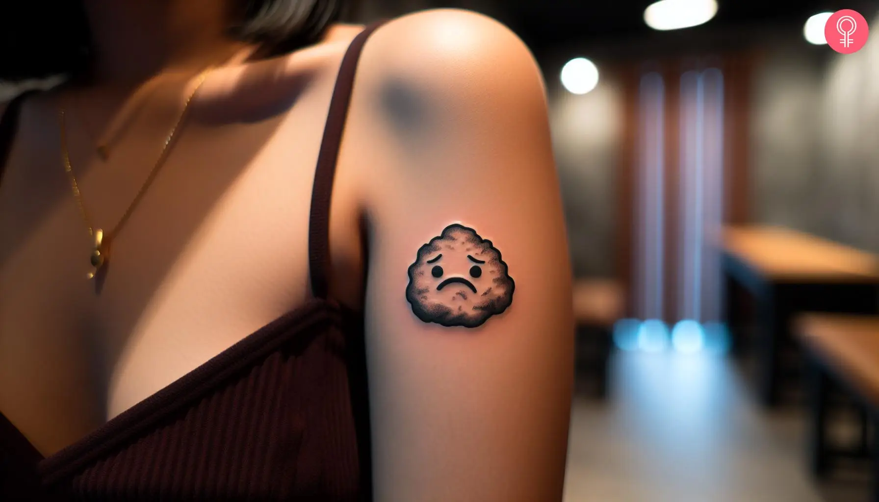 A black-and-white chicken nugget tattoo on a woman’s upper arm