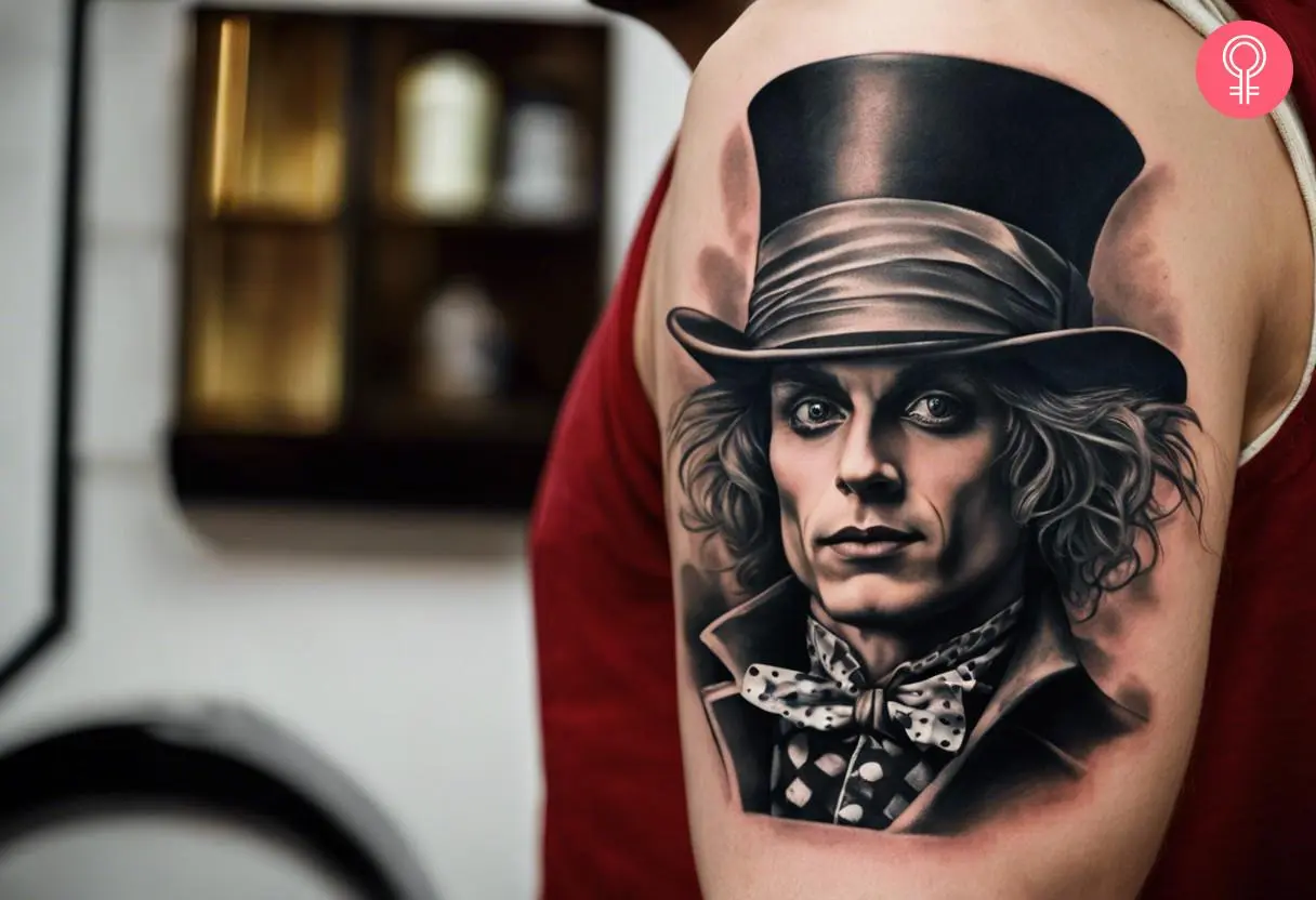 A black and white Mad Hatter tattoo on a man’s upper arm