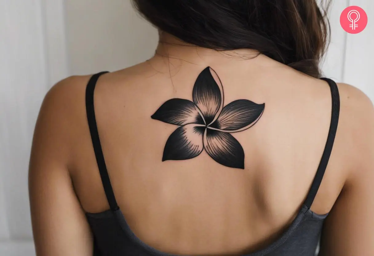 Black Plumeria tattoo on the back shoulder