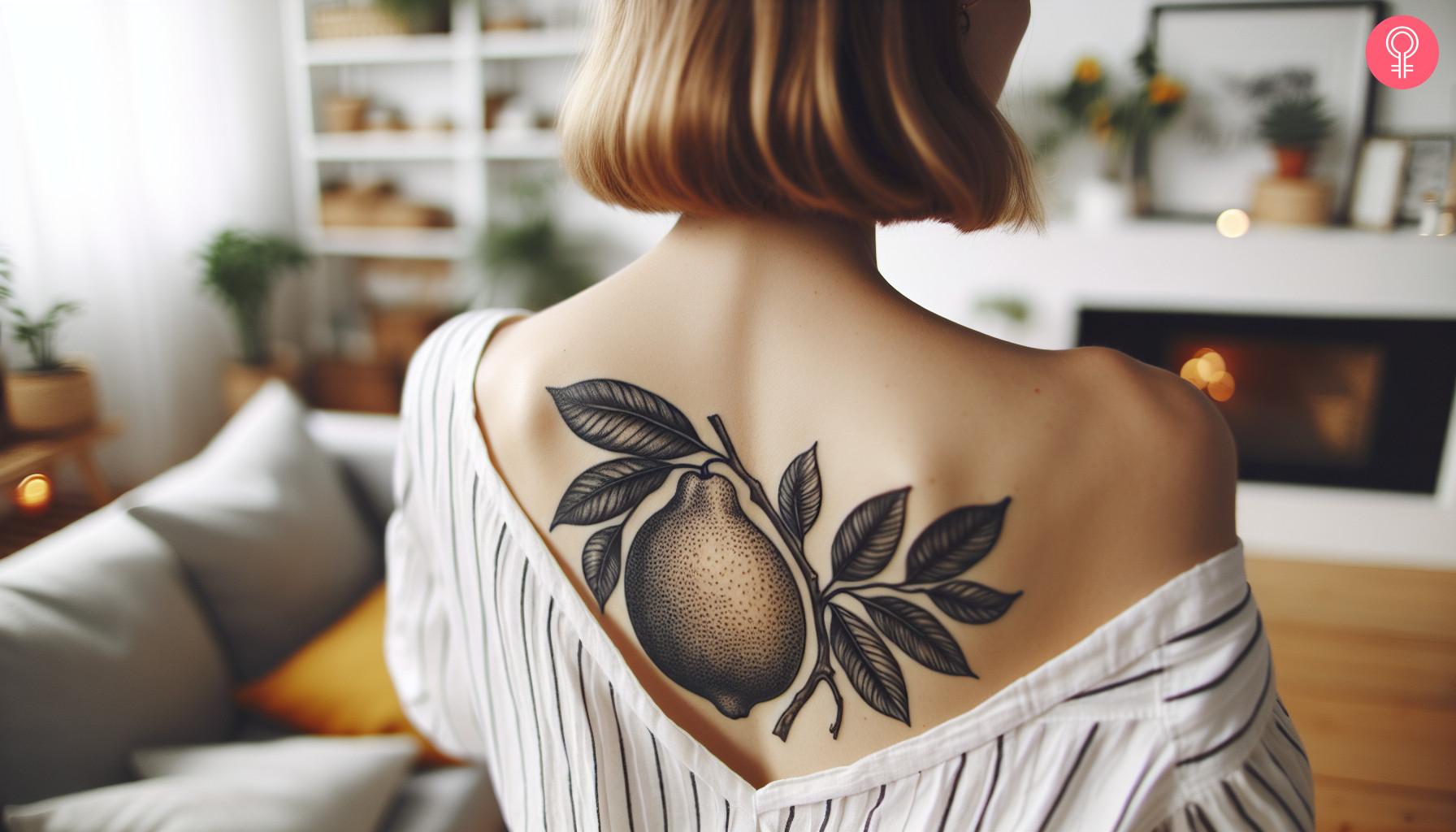 Black and white lemon tattoo on the upper back