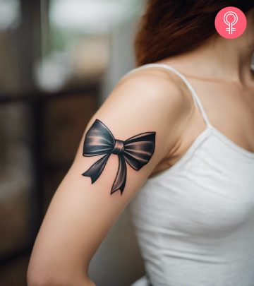 A woman wearing a ‘minimalist mouse’ tattoo on the upper arm.