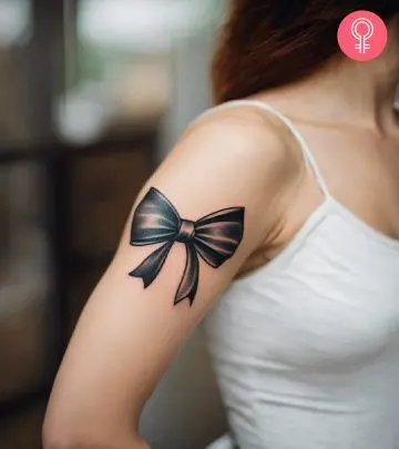 A woman wearing a ‘family birth flower bouquet’ tattoo on the upper arm.