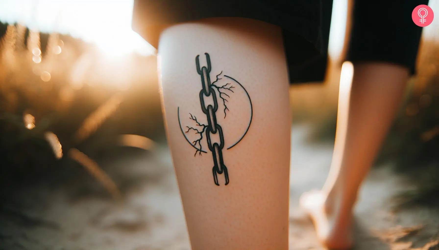 Woman with a broken chain minimalist tattoo on the leg