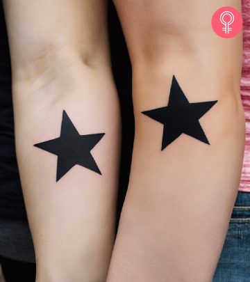 A cross tattoo on the wrists of two sisters