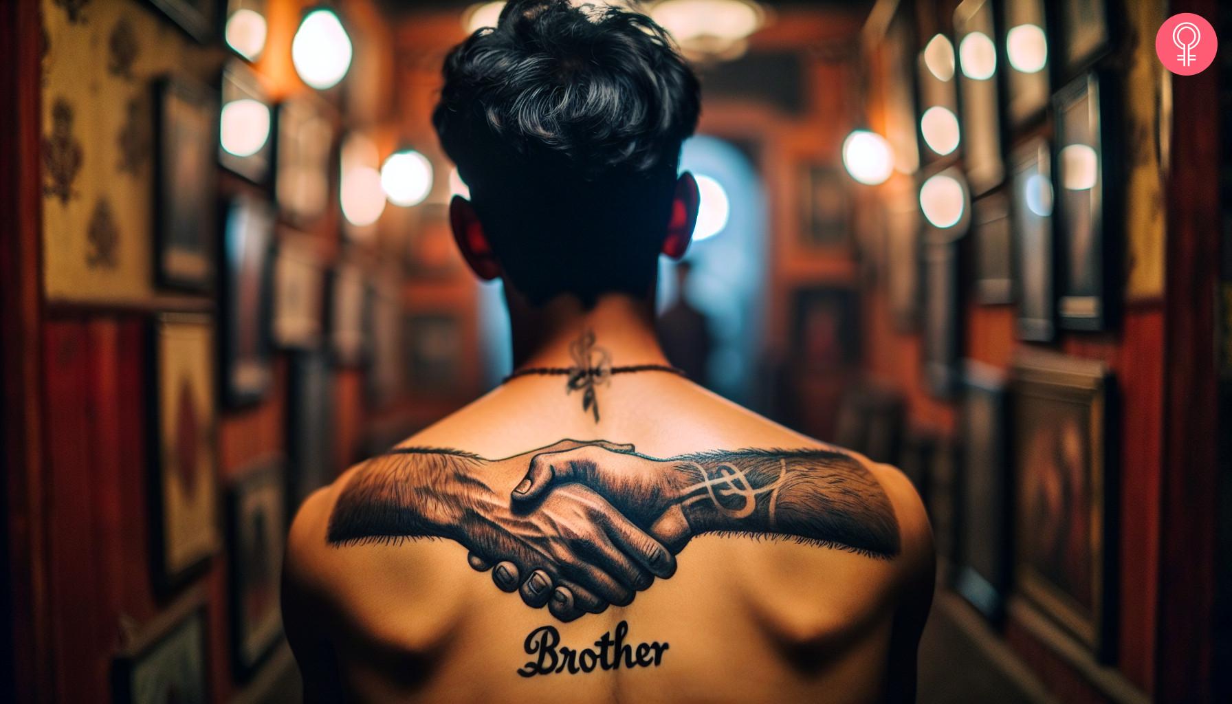 Brotherly handshake tattoo on a man's upper back