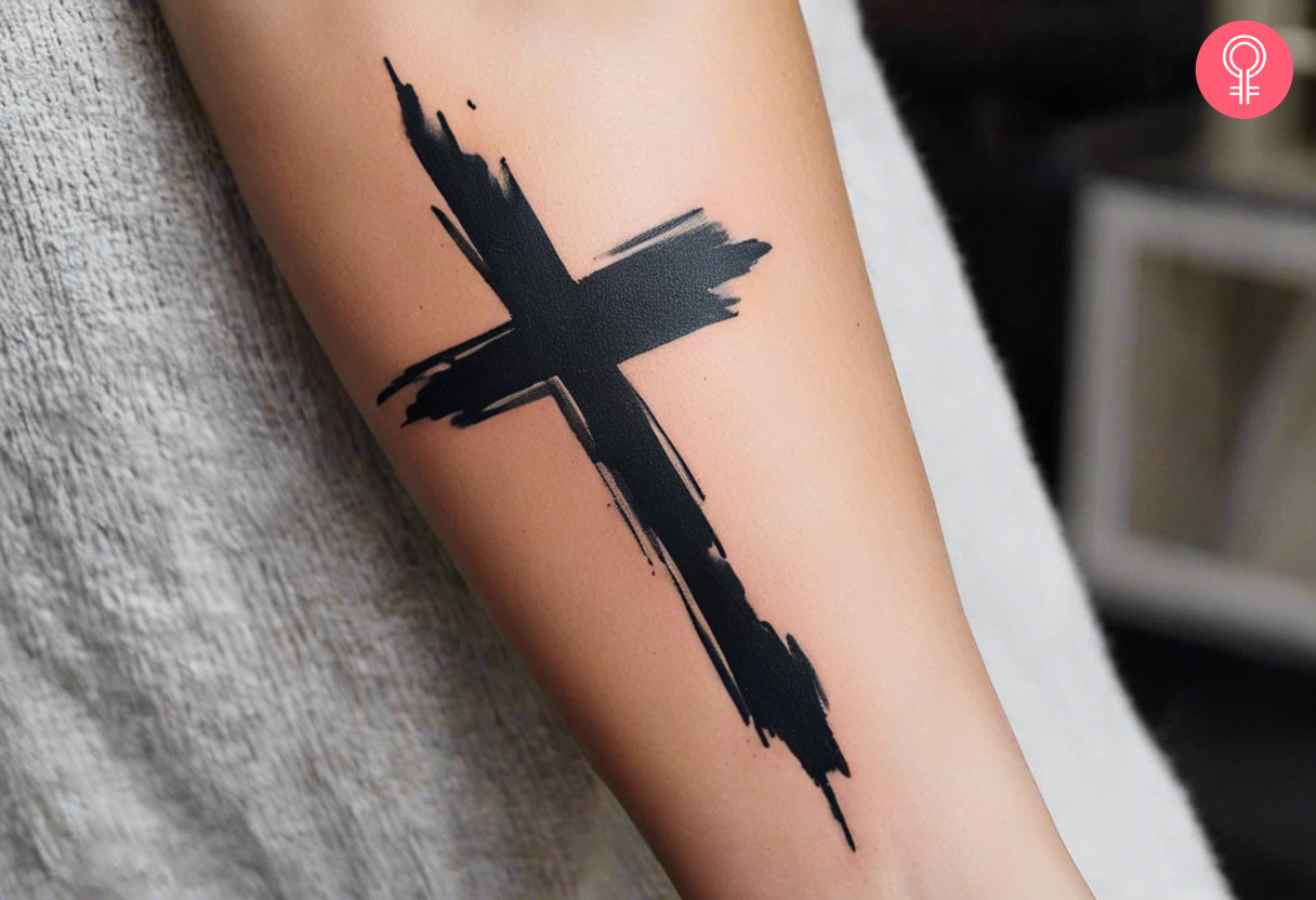 Brush stroke cross tattoo on the forearm