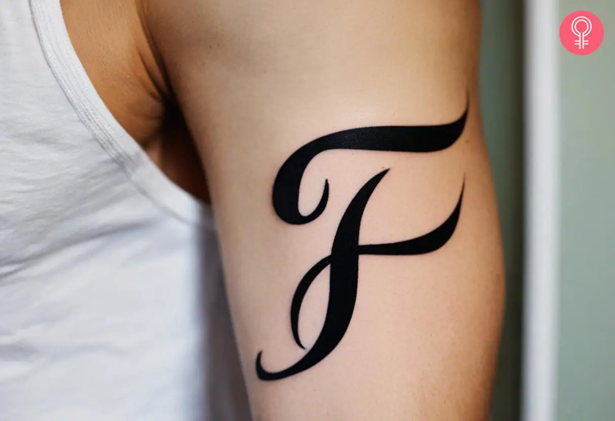 Calligraphy Letter F tattoo on the upper arm