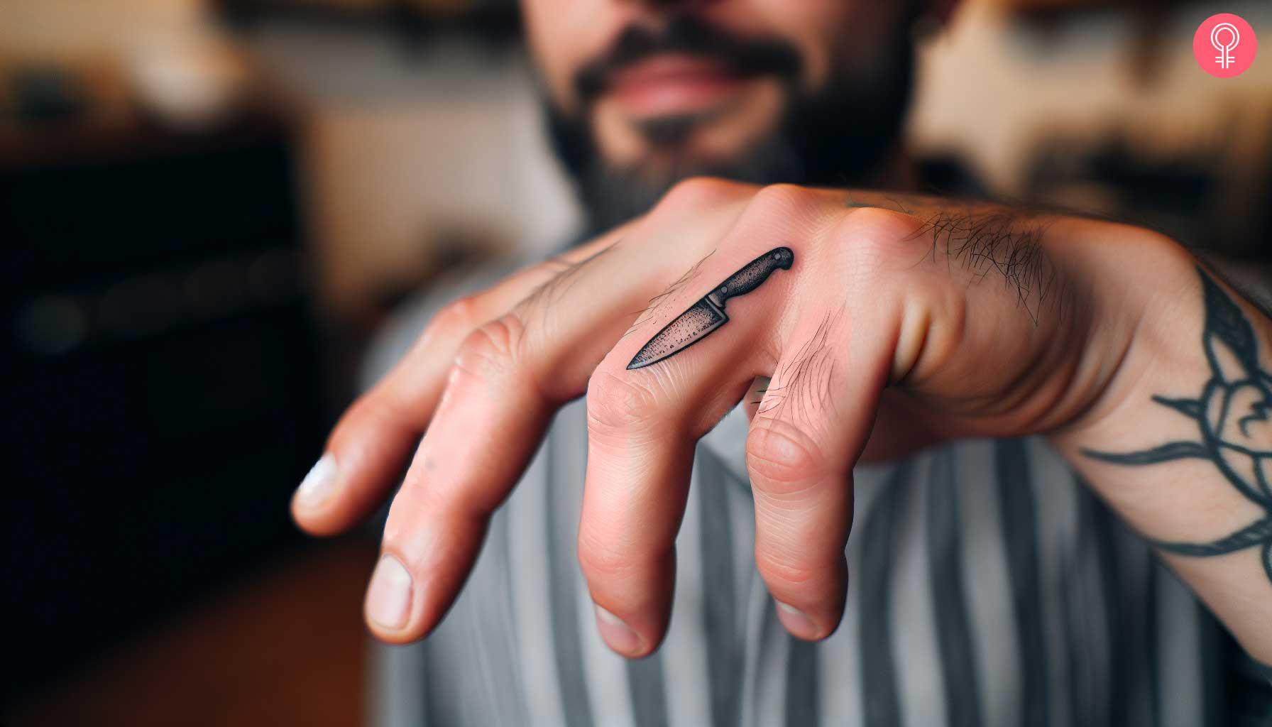 Chef knife tattoo on the finger of a man