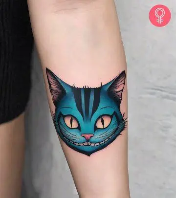 Cheshire cat tattoo on the upper arm