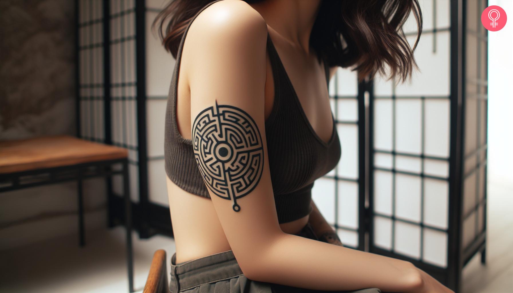 Circle maze tattoo on the upper arm of a woman