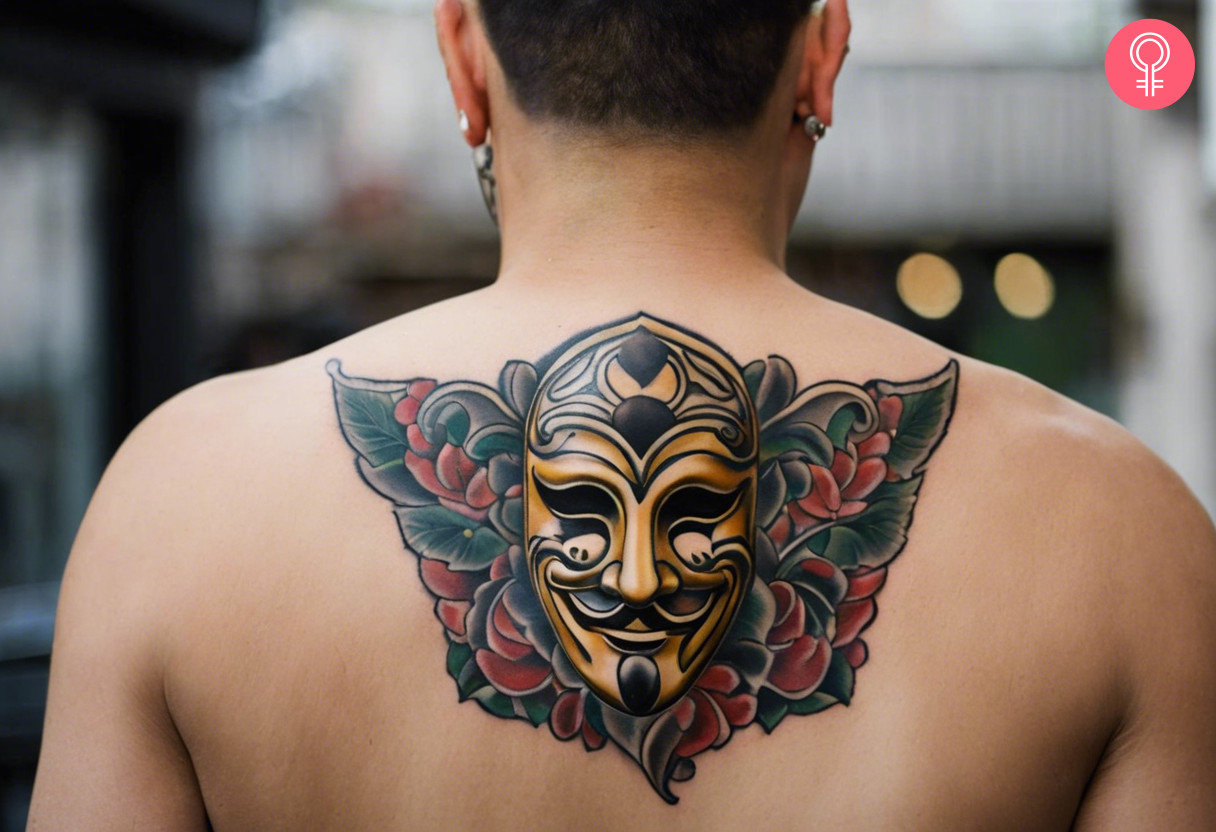 Comedy drama mask tattoo on the upper back