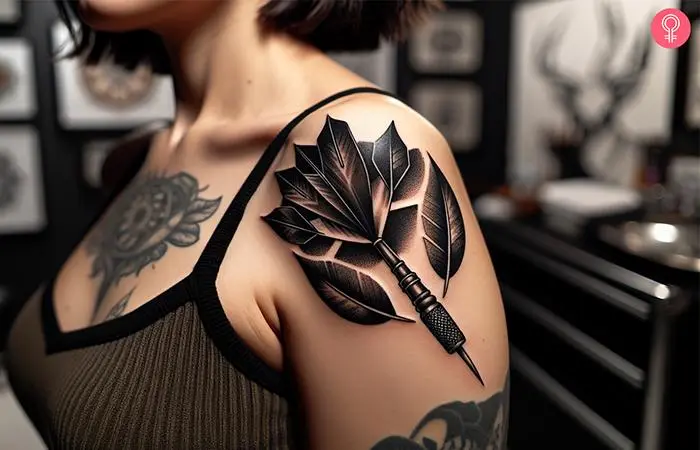 Woman with a dark dart tattoo on the upper arm