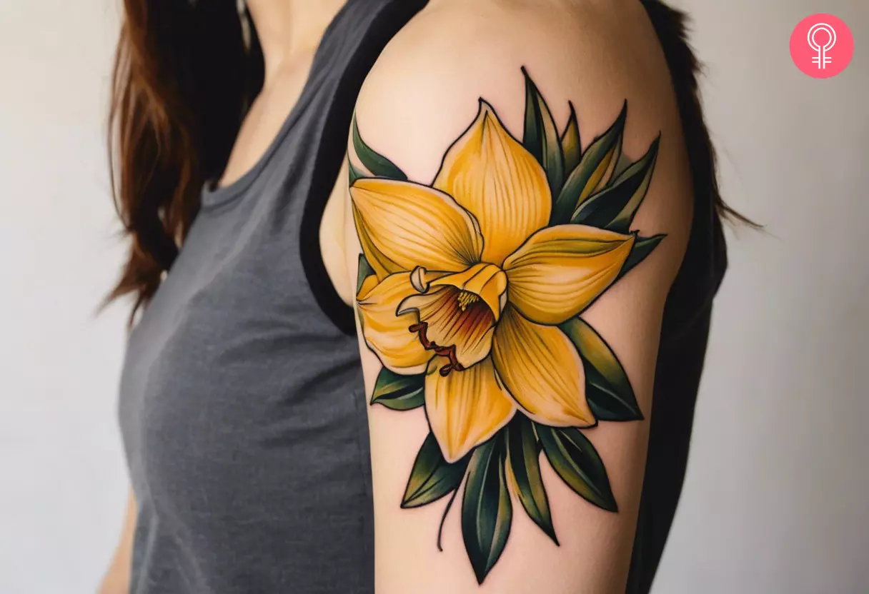 A December narcissus flower tattoo on a woman’s upper arm