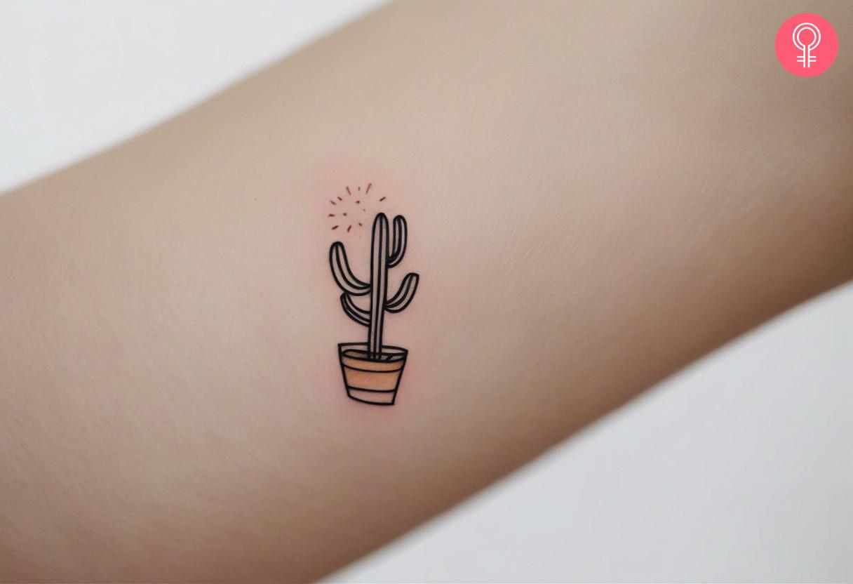 A minimalist cactus tattoo on the arm