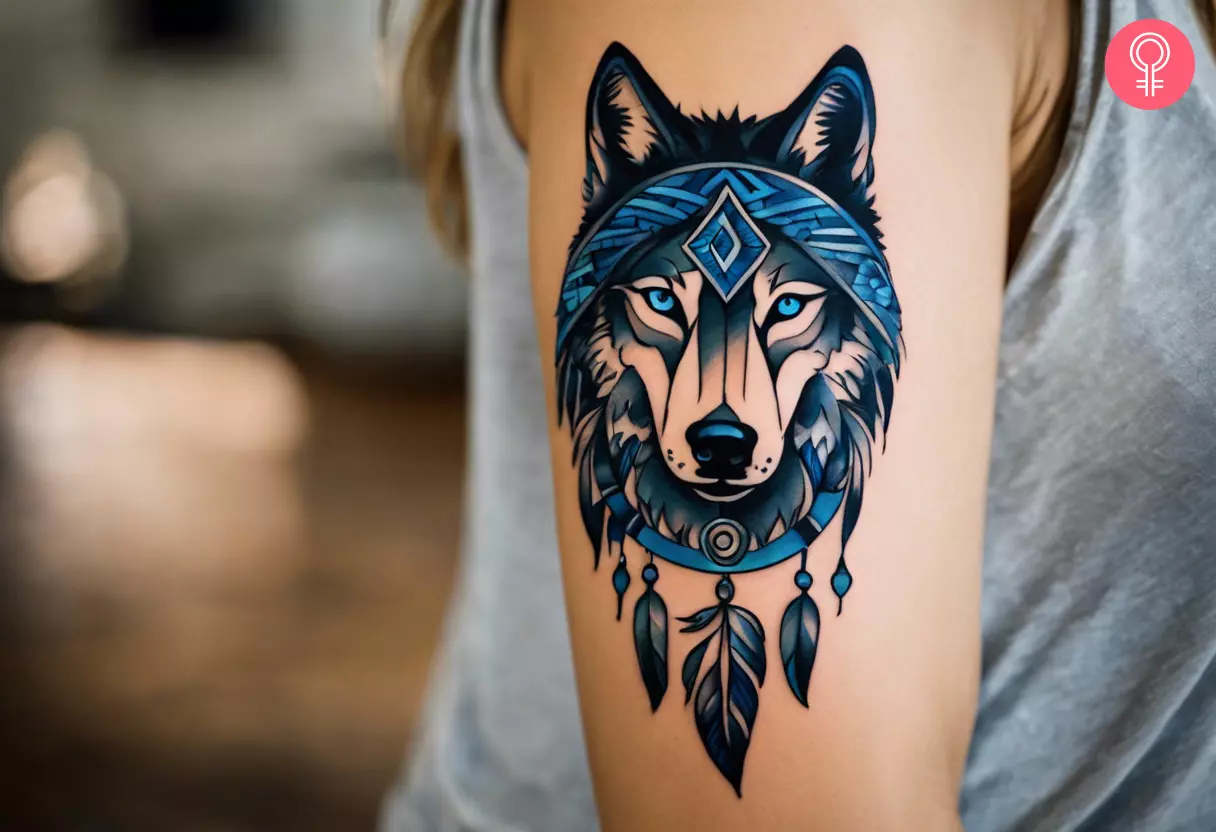 Tribal wolf dreamcatcher tattoo on a woman’s arm