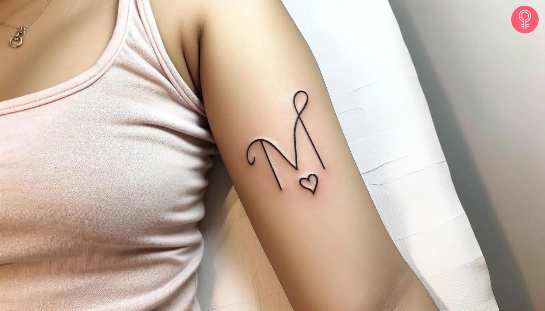 Expressive ‘M’ font tattoo with a heart on the upper arm