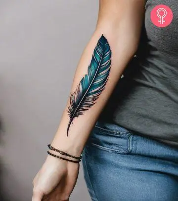 A woman with a black quill tattoo on her upper arm