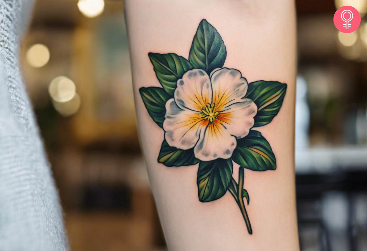 A woman with a white primrose tattoo on her upper arm