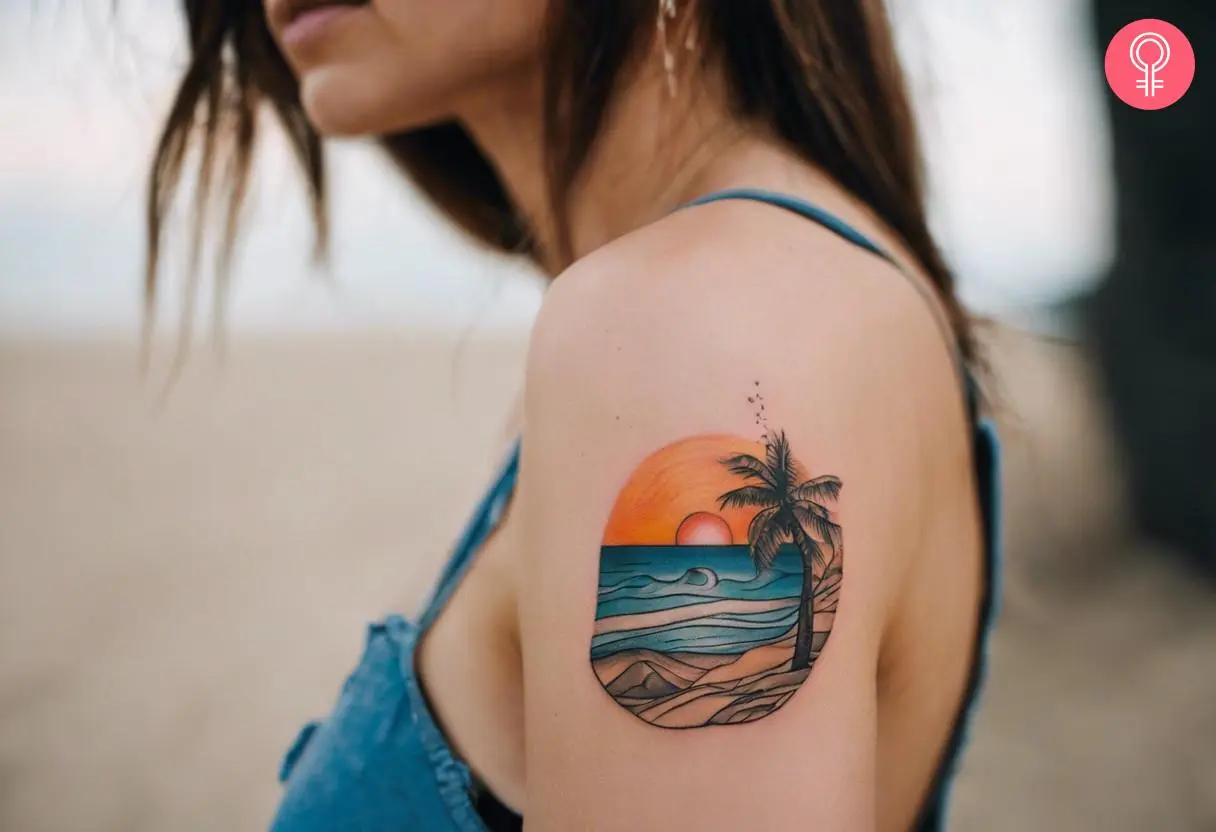 A small scenic beach tattoo with the setting sun on the upper arm