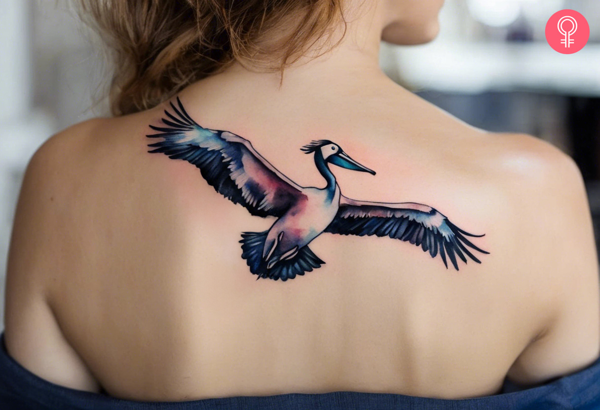 A watercolor tattoo of a flying Pelican on the upper back