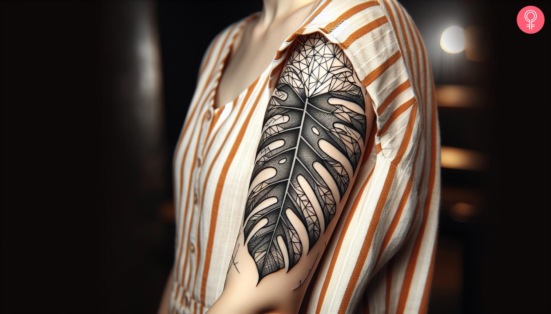 Geometric Monstera tattoo on a woman’s upper arm