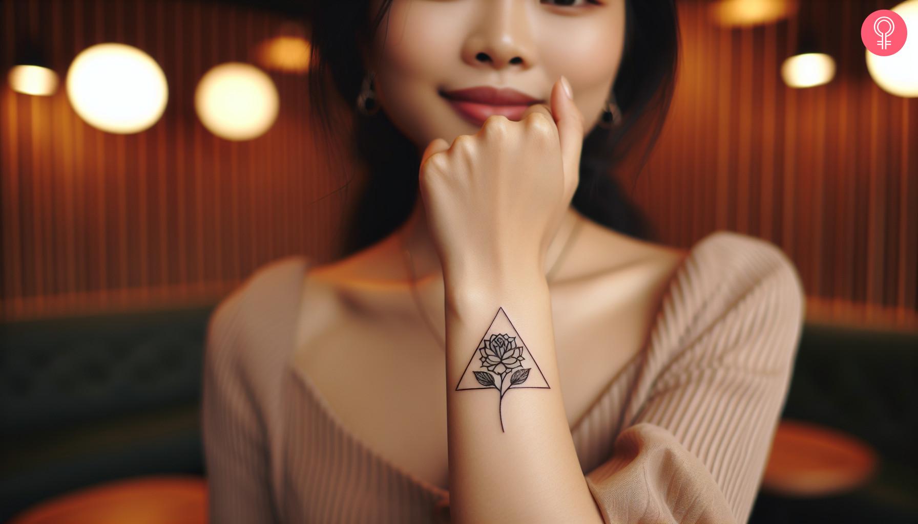 Geometric triangular flower tattoo on a woman's forearm