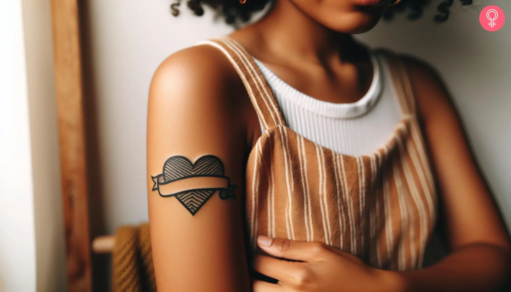 Heart with a banner tattoo on the upper arm of a woman