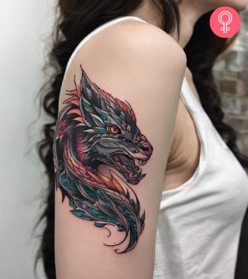 A woman with a colorful tiger rose tattoo on her upper arm