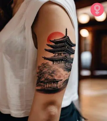 Pagoda tattoo on the upper arm of a woman