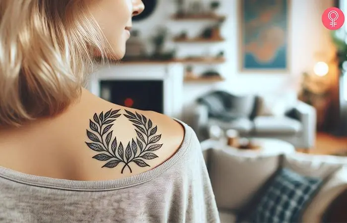 A laurel wreath tattoo on the back shoulder of a woman