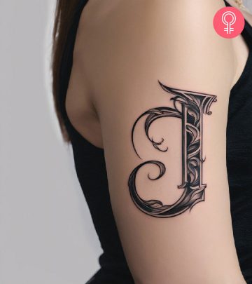 A woman wearing a ‘T’ style letter tattoo on the upper arm.