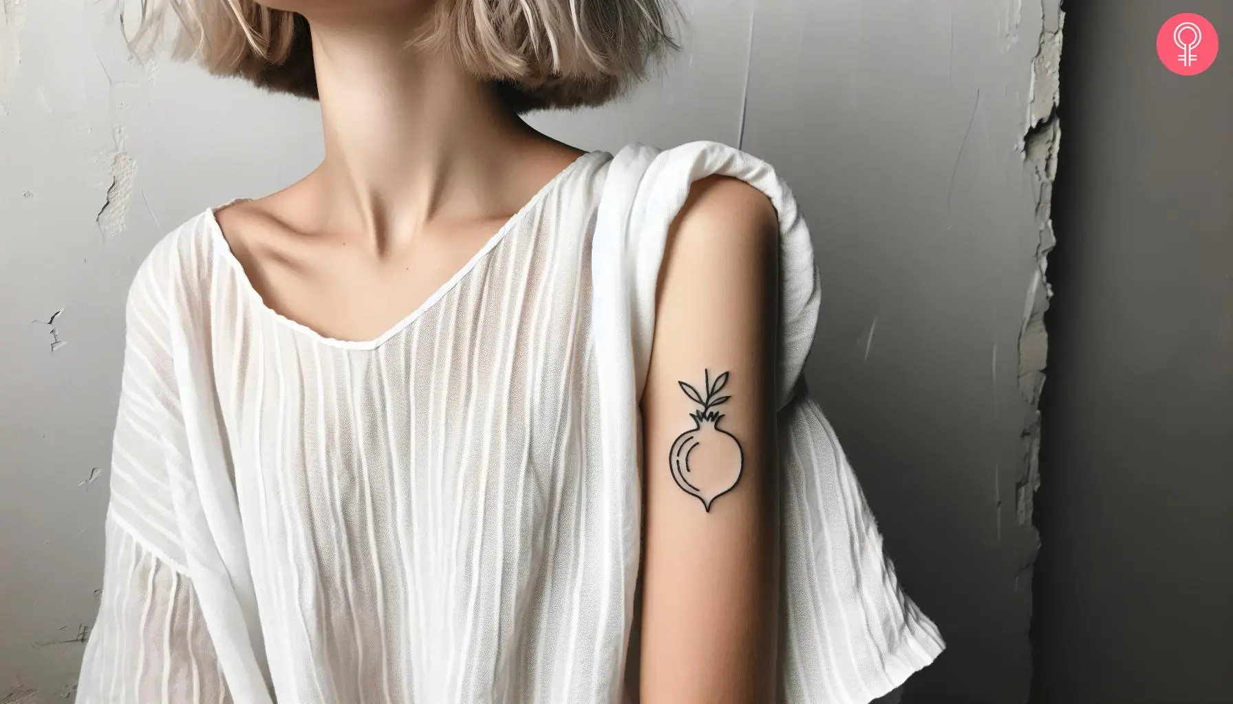 Woman with fine line pomegranate tattoo on her upper arm