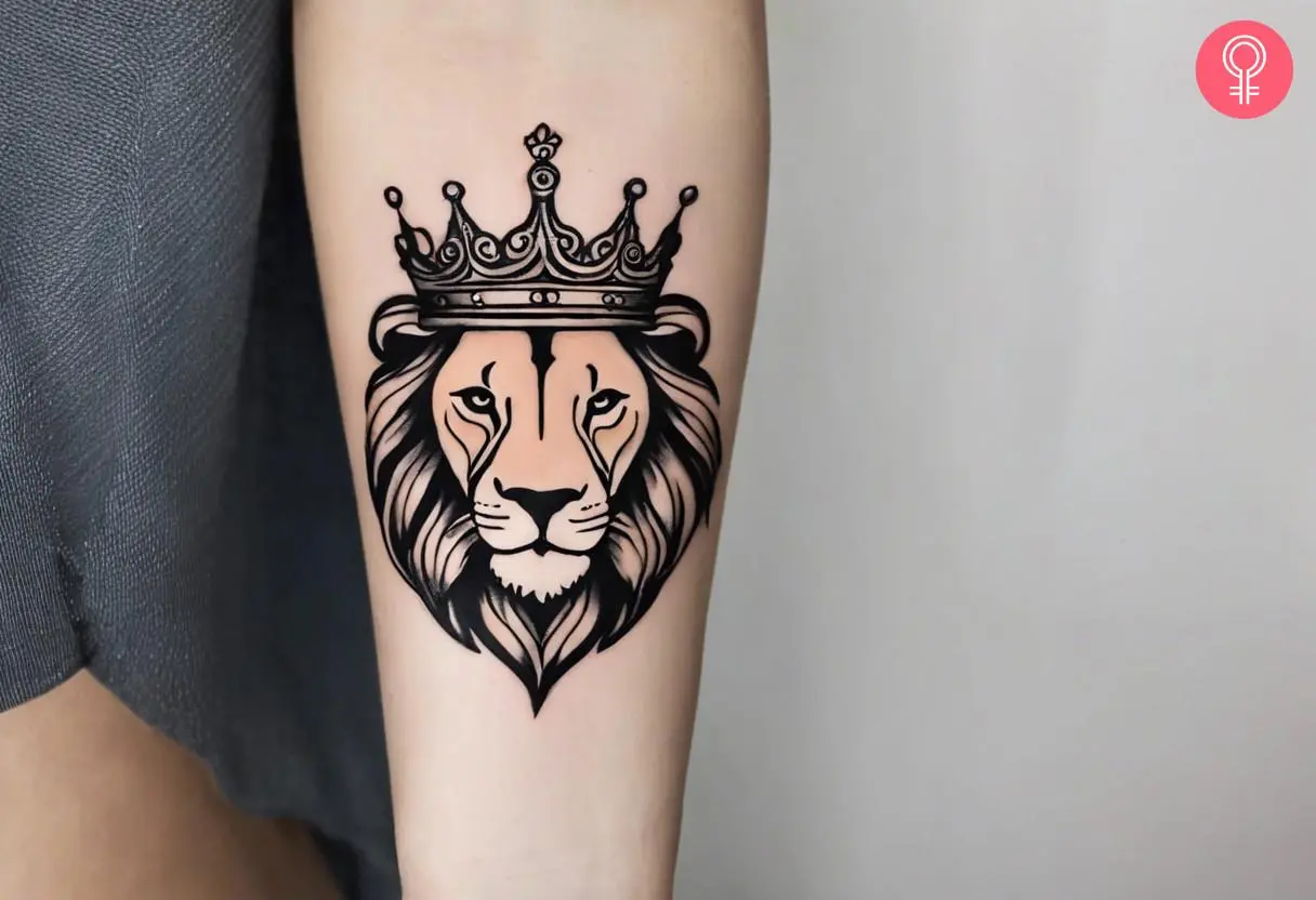 A traditional black ink lion with a crown tattoo on the arm