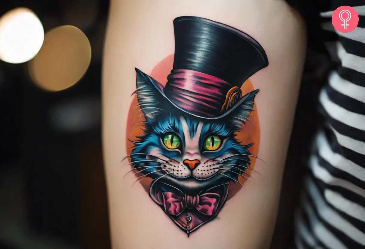 Mad hatter cheshire cat tattoo on the upper arm