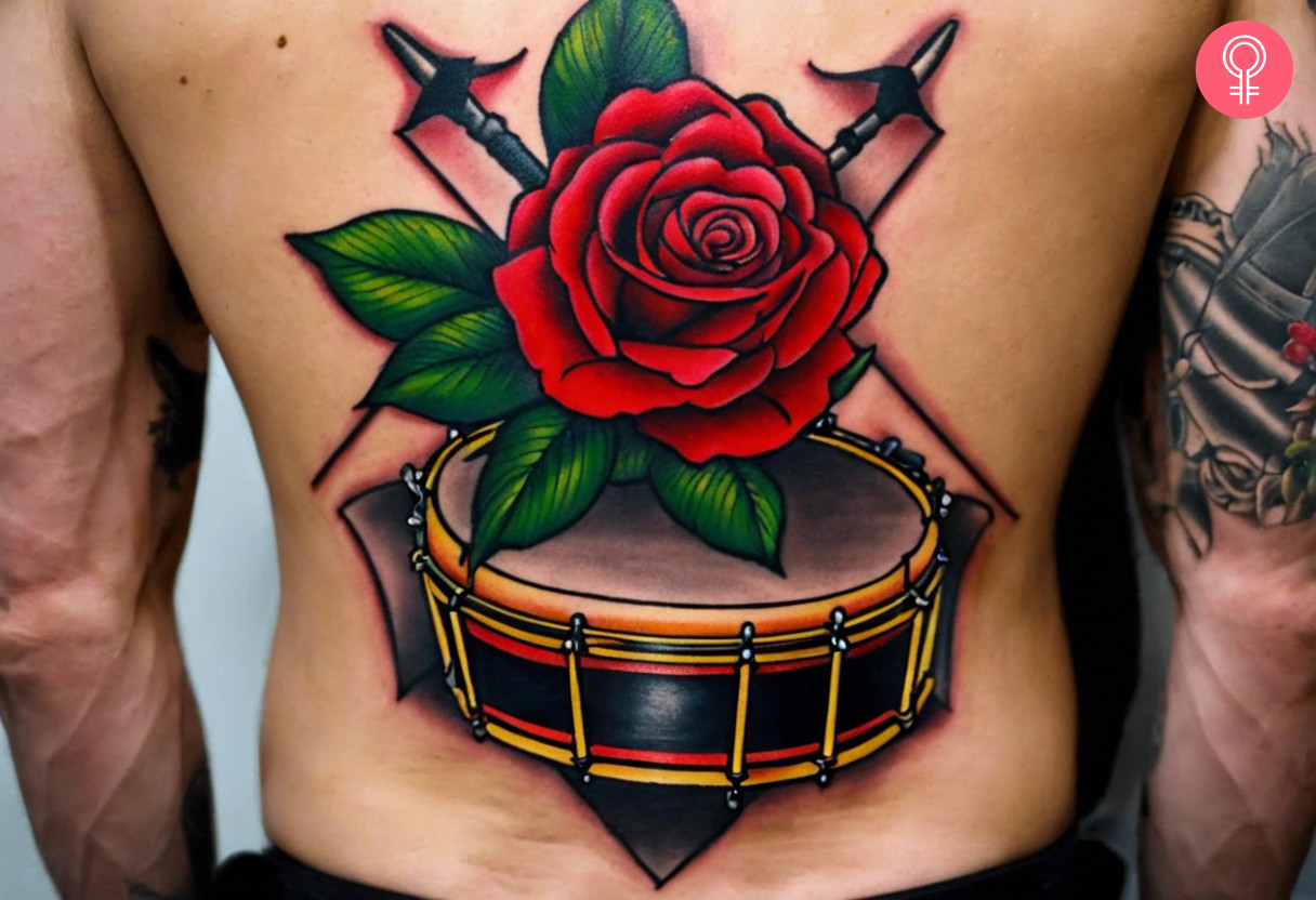 Man with a red rose drummer tattoo on the lower back