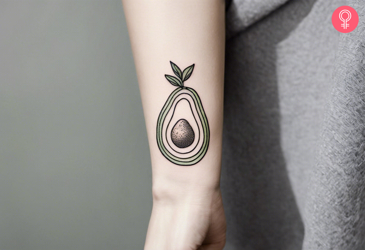 Minimalist avocado tattoo on the forearm of a woman