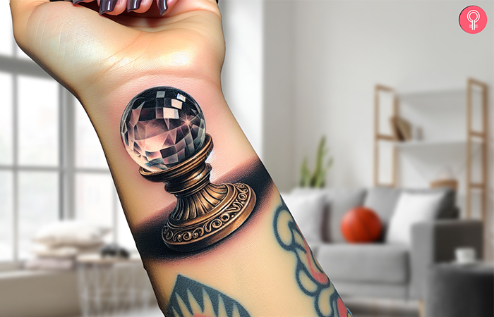 A woman with a minimalist crystal ball tattoo on her wrist