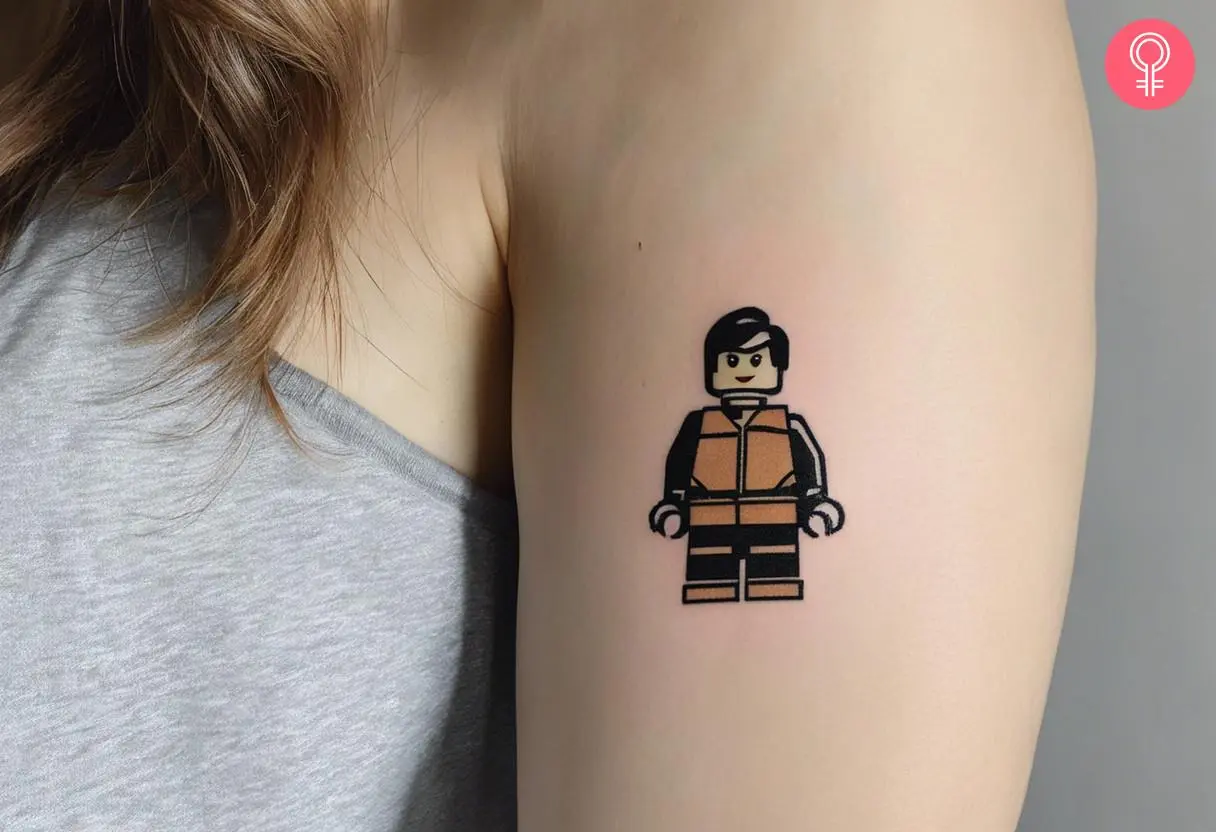 A woman with a colored LEGO man tattoo on her upper arm