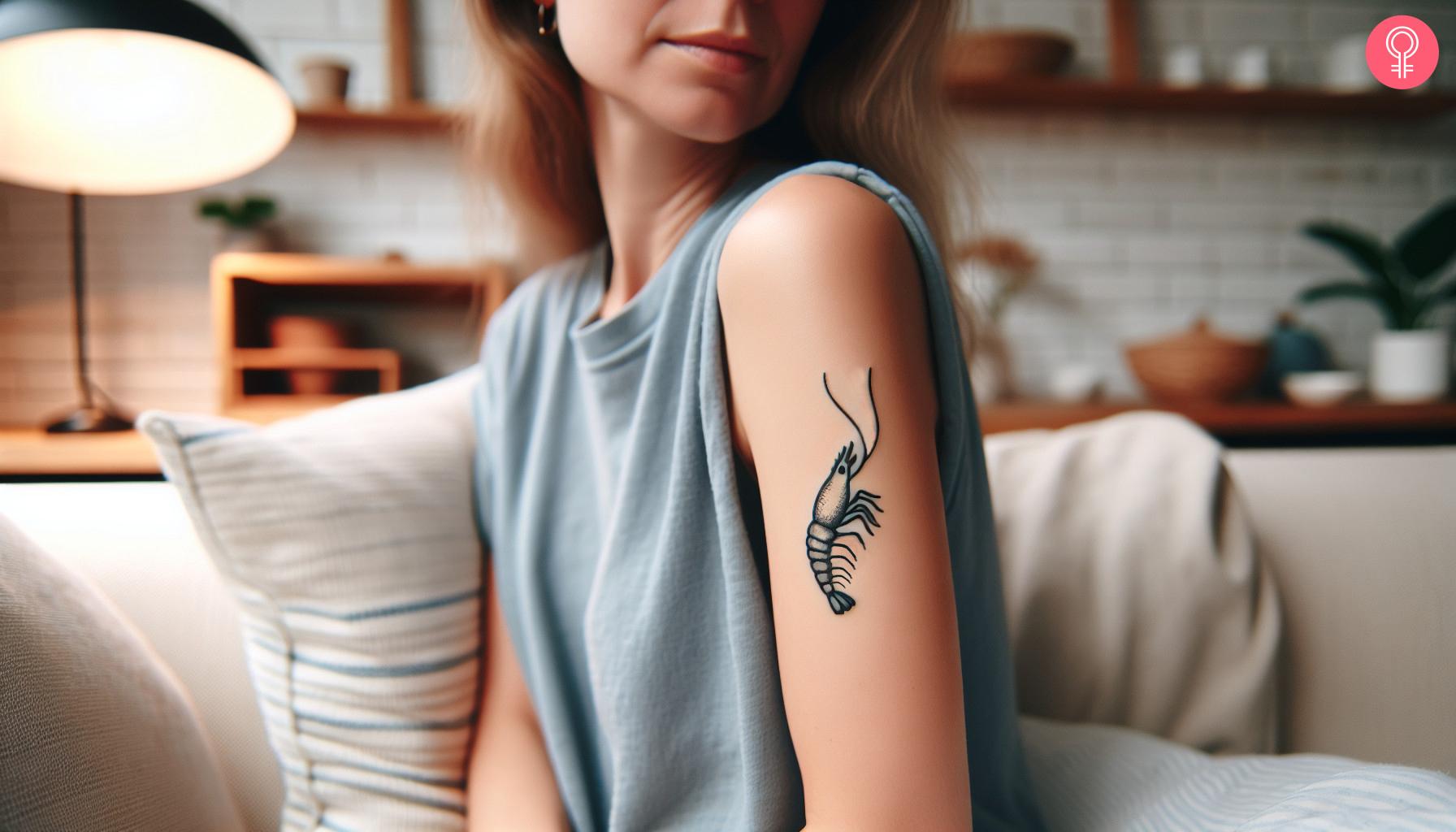 Minimalist shrimp tattoo on a woman's upper arm