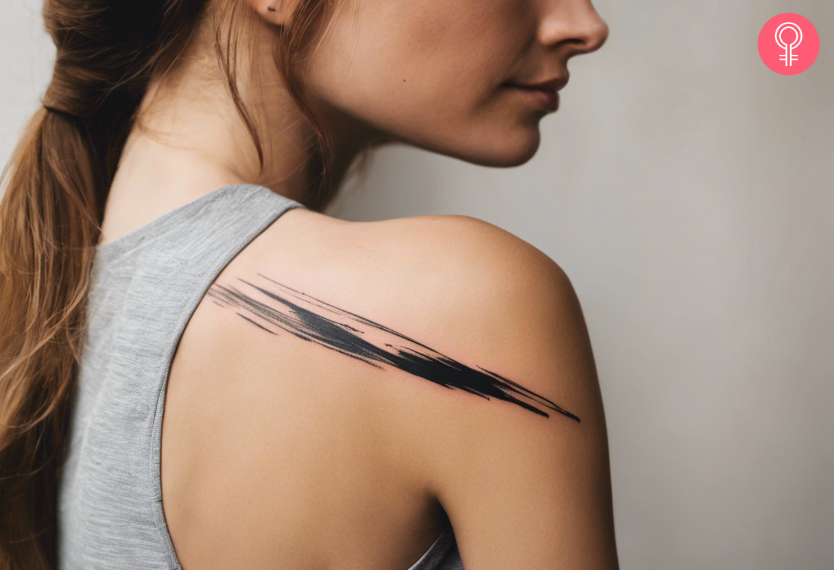 Minimalist brush stroke tattoo on the shoulder