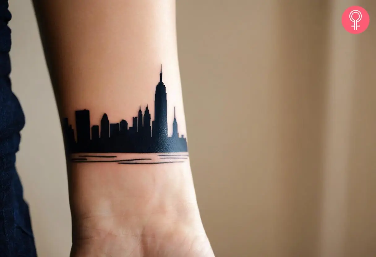 A New York skyline silhouette tattoo on the wrist of a woman