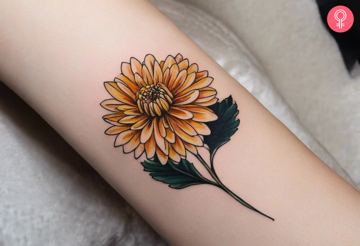 An orange chrysanthemum inked on the forearm