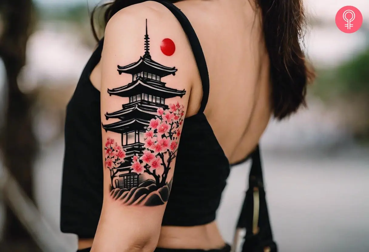 Pagoda cherry blossom tattoo on the upper arm of a woman