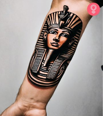 A woman with an Anubis and hieroglyphics tattoo on the upper arm