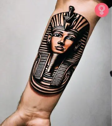 A woman with an Anubis and hieroglyphics tattoo on the upper arm