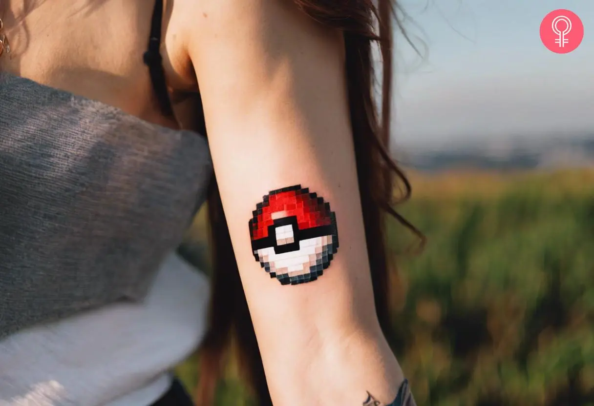 Pixel pokeball tattoo on a woman’s upper arm